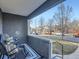 Relaxing front porch with two wicker chairs, view of street at 2824 Cherry St, Denver, CO 80207