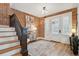 Elegant foyer featuring wood floors, a staircase, exposed brick, and stylish decor at 1661 Adams St, Denver, CO 80206