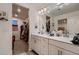 Bathroom featuring double sinks, white cabinets, and a walk in closet at 21538 E 59Th Pl, Aurora, CO 80019