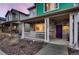 Stylish two-story home with a covered porch and a vibrant purple front door at 21538 E 59Th Pl, Aurora, CO 80019