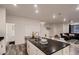 Modern kitchen featuring a large island with dark countertops and white cabinets at 21538 E 59Th Pl, Aurora, CO 80019