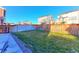 Beautiful backyard featuring a green lawn, complemented by a wood fence for privacy, and a concrete patio at 9448 Richfield St, Commerce City, CO 80022