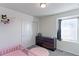 Cozy bedroom featuring a pink crib, dark dresser, and ample natural light at 9448 Richfield St, Commerce City, CO 80022