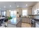 Bright, modern kitchen with gray cabinets, stainless steel appliances, and a view to the backyard at 9448 Richfield St, Commerce City, CO 80022