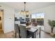 Elegant dining space with backyard views, stylish chandelier, and seamless flow to the modern kitchen at 3855 S Monaco St # 182, Denver, CO 80237