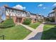 Manicured lawns and walkways lead to charming townhomes in this exterior view at 3855 S Monaco St # 182, Denver, CO 80237