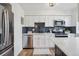 Updated kitchen features stainless steel appliances, white cabinets, subway tile backsplash, and quartz countertops at 3855 S Monaco St # 182, Denver, CO 80237