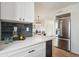 Bright kitchen featuring stainless steel refrigerator, quartz counters, and open floorplan to dining area at 3855 S Monaco St # 182, Denver, CO 80237