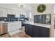 Modern kitchen featuring white cabinets, subway tile backsplash, stainless appliances, and stylish island at 3855 S Monaco St # 182, Denver, CO 80237