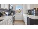 Cozy kitchen boasts stainless steel appliances, subway tile backsplash, white cabinets, and hardwood floors at 3855 S Monaco St # 182, Denver, CO 80237