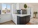 Charming kitchen island with quartz countertop, white cabinets, and dark blue accent cabinets and decor at 3855 S Monaco St # 182, Denver, CO 80237