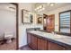 Bathroom with double vanity, tile countertop, and shower behind a wooden door at 12036 Monaco Dr, Brighton, CO 80602