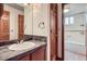 Bathroom featuring a sink and doorway to a tub with tiled walls at 12036 Monaco Dr, Brighton, CO 80602
