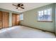Bedroom with ceiling fan, windows, and closet with wood doors at 12036 Monaco Dr, Brighton, CO 80602