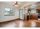 Dining area showcasing hardwood floors, a window and is open to the kitchen at 12036 Monaco Dr, Brighton, CO 80602