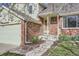 Inviting front entrance with brick accents, a light-colored exterior, and steps leading to the front door at 12036 Monaco Dr, Brighton, CO 80602