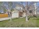 Lovely two-story home with brick and light siding, a green lawn, and mature trees in the front yard at 12036 Monaco Dr, Brighton, CO 80602
