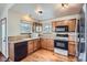 Traditional kitchen with wood cabinets, black appliances, and granite countertops at 12036 Monaco Dr, Brighton, CO 80602