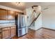 Open kitchen with stainless steel refrigerator and view of the carpeted staircase at 12036 Monaco Dr, Brighton, CO 80602