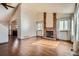 Bright living room featuring hardwood floors, a brick fireplace, and large windows for natural light at 12036 Monaco Dr, Brighton, CO 80602