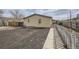 Exterior backyard featuring gravel, partial fencing, and small home elevation at 130 Elm St, Hudson, CO 80642