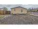 Exterior backyard featuring gravel, partial fencing, and small home elevation at 130 Elm St, Hudson, CO 80642