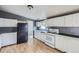 The kitchen has white cabinets, a black refrigerator, a white gas stove and a view to the hall at 130 Elm St, Hudson, CO 80642