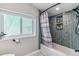 Bathroom featuring tub with tiled surround, shower curtain, and a bright window at 1325 S Ivy Way, Denver, CO 80224
