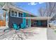 Modern home exterior with blue accents, carport, and well-manicured front yard at 1325 S Ivy Way, Denver, CO 80224
