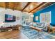 Comfortable living room with wood-beamed ceilings, blue accent wall, and modern decor at 1325 S Ivy Way, Denver, CO 80224