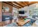Inviting living room with fireplace, wood-beamed ceilings, and sliding doors to the backyard at 1325 S Ivy Way, Denver, CO 80224