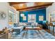 Living room with wood-beamed ceilings, a blue accent wall, and modern decor at 1325 S Ivy Way, Denver, CO 80224