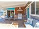 Covered outdoor kitchen featuring a built-in grill, ample seating, and stone accents at 1325 S Ivy Way, Denver, CO 80224
