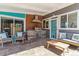 Covered outdoor kitchen featuring a built-in grill, ample seating, and stone accents at 1325 S Ivy Way, Denver, CO 80224