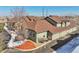 Aerial view showcasing townhome exteriors, multiple car garages, landscaping, and some remaining winter snow at 2733 W Greens Ln, Littleton, CO 80123