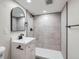 Updated bathroom features a white vanity, grey tile shower, and modern fixtures at 1040 Hoover Ave, Fort Lupton, CO 80621