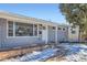 Front view of a Ranch style home with gray siding, white trim, and a stone base at 1040 Hoover Ave, Fort Lupton, CO 80621