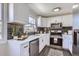 Updated kitchen featuring white cabinets, stainless steel appliances, and a stylish backsplash at 1040 Hoover Ave, Fort Lupton, CO 80621