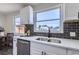 Modern kitchen with white cabinets, dark tile backsplash, and stainless steel appliances at 1040 Hoover Ave, Fort Lupton, CO 80621