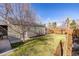 Well-maintained backyard with green grass, mature trees, and a fenced perimeter at 860 Magnolia St, Denver, CO 80220