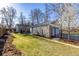 Large backyard with lush lawn, detached garage, mature trees, and a privacy fence at 860 Magnolia St, Denver, CO 80220