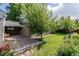 Backyard features lush lawn, greenery, garden, driveway, and detached garage at 860 Magnolia St, Denver, CO 80220