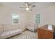 Bright bedroom with hardwood floors, ceiling fan, two windows, and two wood cribs at 860 Magnolia St, Denver, CO 80220