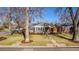 Charming home with a well-manicured lawn, mature trees, and a cozy front porch at 860 Magnolia St, Denver, CO 80220