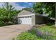 Detached garage with automatic door, driveway, and mature landscaping at 860 Magnolia St, Denver, CO 80220