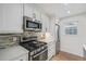 Modern kitchen featuring white cabinets, stainless steel appliances, and a tiled backsplash at 860 Magnolia St, Denver, CO 80220