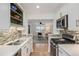 Well-lit kitchen with white cabinets, modern appliances, and an open view into the living room at 860 Magnolia St, Denver, CO 80220
