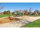 A vibrant playground featuring climbing structures and slides, surrounded by lush green grass and mature trees at 860 Magnolia St, Denver, CO 80220