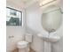 Modern half bath featuring pedestal sink, oval mirror, and neutral finishes at 2032 S Holly St # 3, Denver, CO 80222