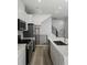 Modern kitchen featuring stainless steel appliances, white cabinets, and quartz countertops at 2032 S Holly St # 3, Denver, CO 80222